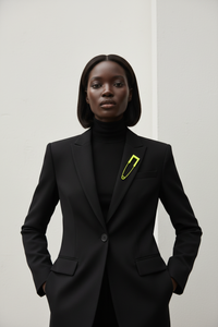 Black turtleneck blazer with yellow safety pin