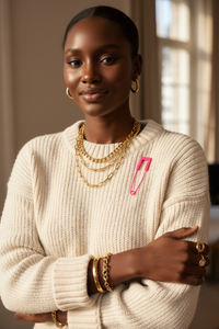 Cream knit sweater with pink safety pin