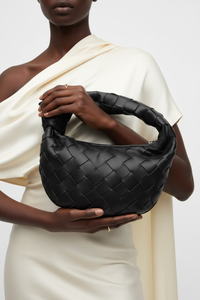 Dark model with black woven knot bag