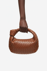 Dark model with brown woven knot bag
