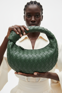 Dark model with dark green woven knot bag