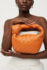 Dark model with orange woven knot bag