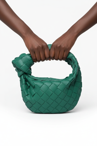Dark model with two hands on green woven knot bag